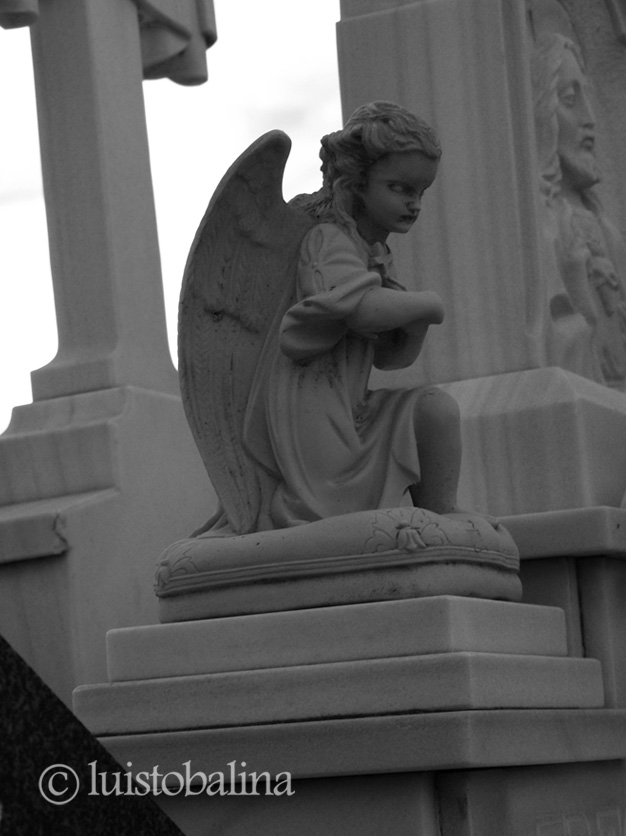 escultura de un ángel sobre una lápida